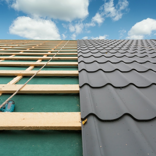 Wood roofing slats with metal shingles and power drill