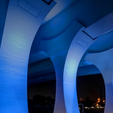 Under view of bridge at night illuminated by blue light